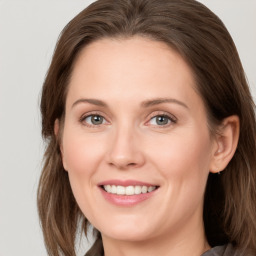 Joyful white young-adult female with long  brown hair and grey eyes