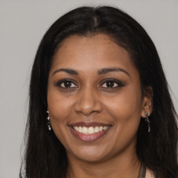 Joyful black young-adult female with long  brown hair and brown eyes