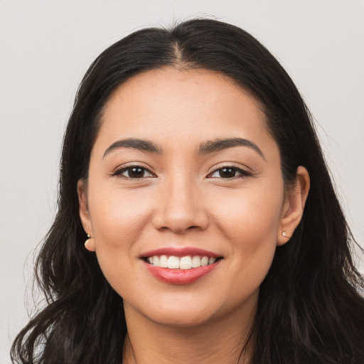 Joyful latino young-adult female with long  brown hair and brown eyes