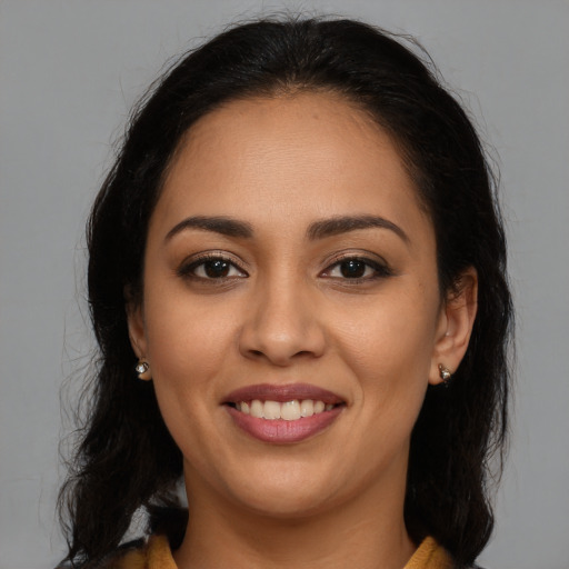 Joyful latino young-adult female with medium  brown hair and brown eyes