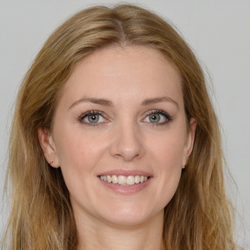 Joyful white young-adult female with long  brown hair and green eyes