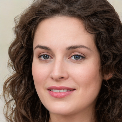 Joyful white young-adult female with long  brown hair and green eyes