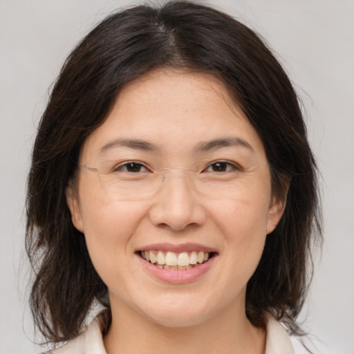 Joyful white adult female with medium  brown hair and brown eyes