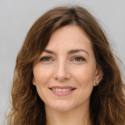 Joyful white adult female with long  brown hair and brown eyes