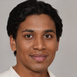 Joyful latino young-adult male with short  brown hair and brown eyes