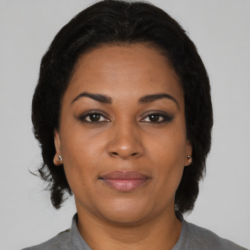 Joyful black adult female with medium  brown hair and brown eyes
