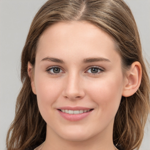 Joyful white young-adult female with long  brown hair and grey eyes