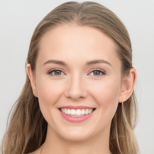 Joyful white young-adult female with long  brown hair and blue eyes