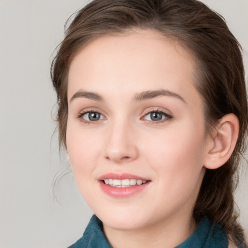 Joyful white young-adult female with medium  brown hair and grey eyes