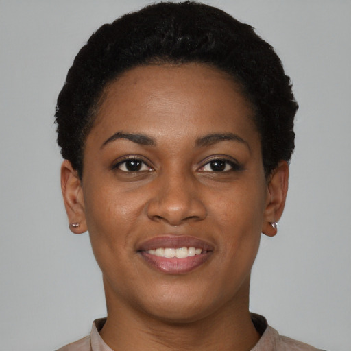 Joyful black young-adult female with short  brown hair and brown eyes