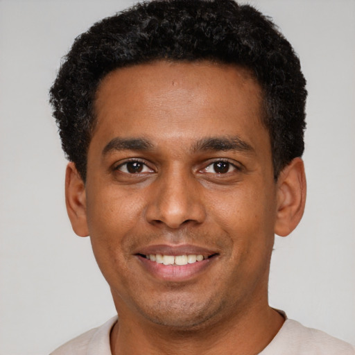Joyful latino young-adult male with short  black hair and brown eyes