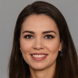 Joyful white young-adult female with long  brown hair and brown eyes