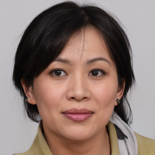 Joyful asian adult female with medium  brown hair and brown eyes