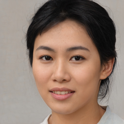 Joyful asian young-adult female with medium  brown hair and brown eyes