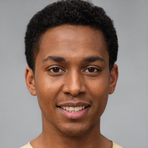 Joyful black young-adult male with short  black hair and brown eyes