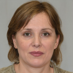 Joyful white adult female with medium  brown hair and blue eyes