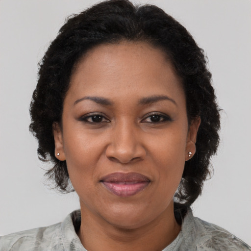 Joyful black adult female with short  black hair and brown eyes