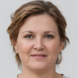 Joyful white adult female with medium  brown hair and grey eyes