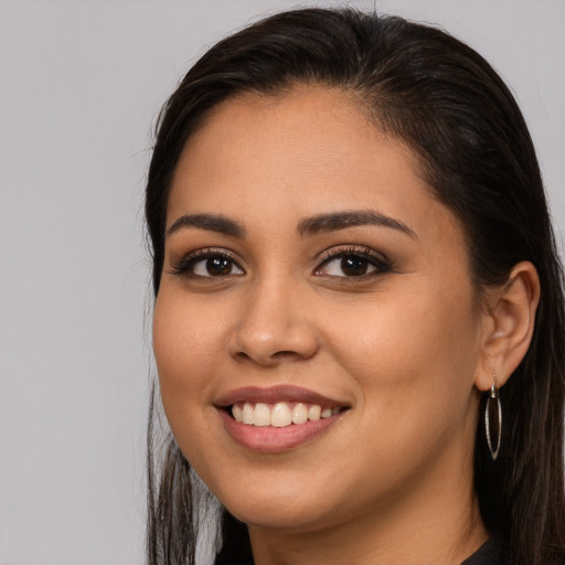 Joyful latino young-adult female with long  brown hair and brown eyes