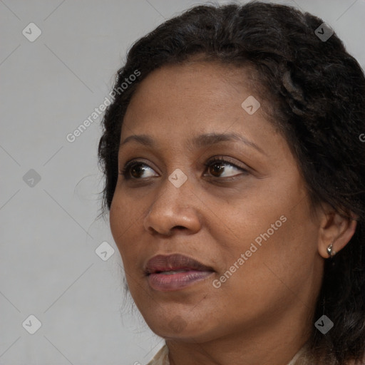 Joyful black adult female with long  brown hair and brown eyes