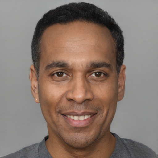 Joyful latino adult male with short  black hair and brown eyes
