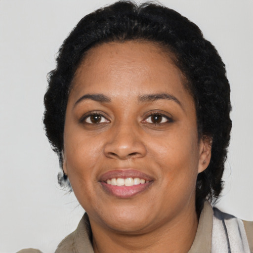 Joyful black adult female with long  black hair and brown eyes