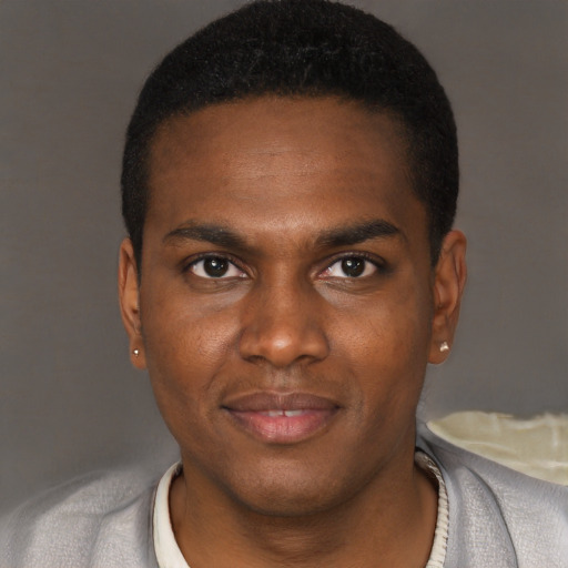 Joyful black young-adult male with short  brown hair and brown eyes