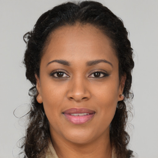 Joyful black young-adult female with long  brown hair and brown eyes