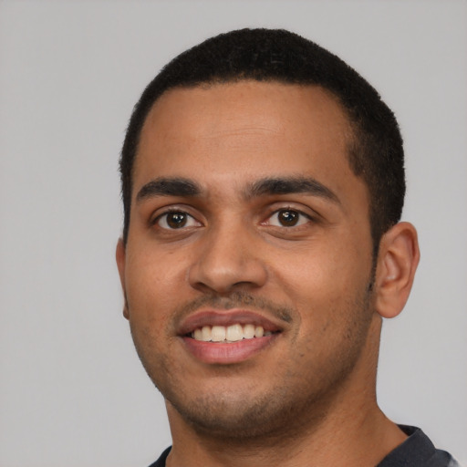 Joyful latino young-adult male with short  black hair and brown eyes