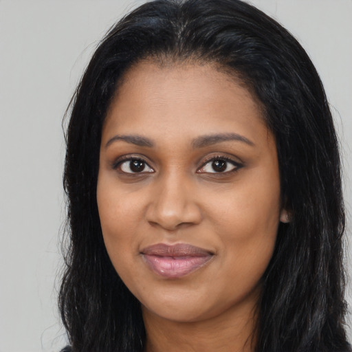 Joyful black young-adult female with long  black hair and brown eyes