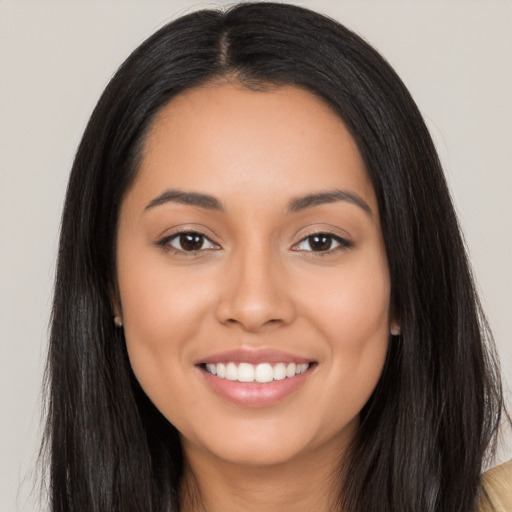 Joyful latino young-adult female with long  black hair and brown eyes