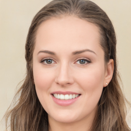 Joyful white young-adult female with long  brown hair and blue eyes