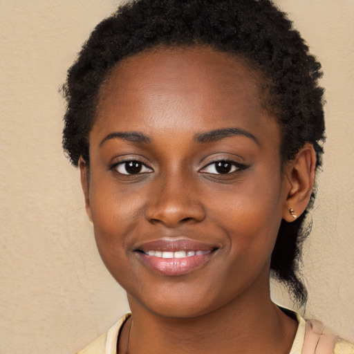 Joyful black young-adult female with long  brown hair and brown eyes