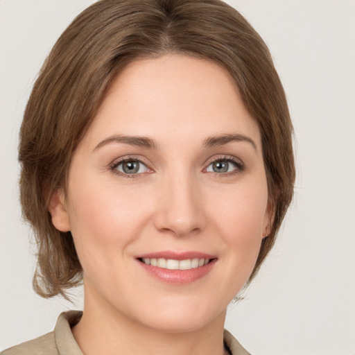 Joyful white young-adult female with medium  brown hair and green eyes