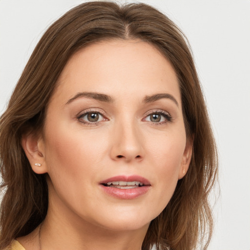 Joyful white young-adult female with long  brown hair and green eyes