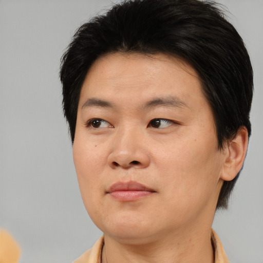 Joyful asian adult male with short  brown hair and brown eyes