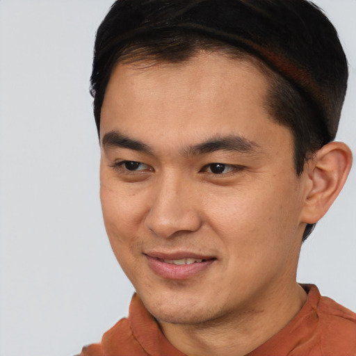 Joyful asian young-adult male with short  brown hair and brown eyes
