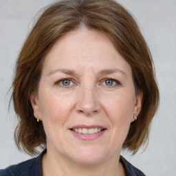 Joyful white adult female with medium  brown hair and grey eyes