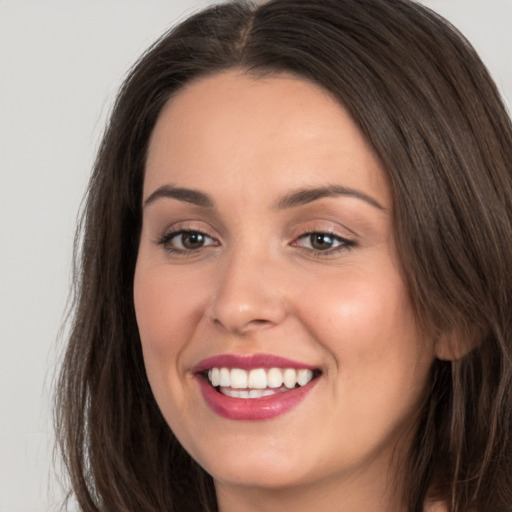 Joyful white young-adult female with long  brown hair and brown eyes