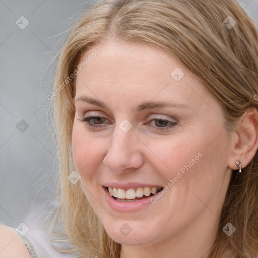 Joyful white young-adult female with long  brown hair and blue eyes