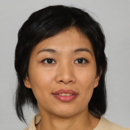 Joyful asian young-adult female with medium  brown hair and brown eyes