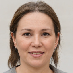 Joyful white adult female with medium  brown hair and grey eyes