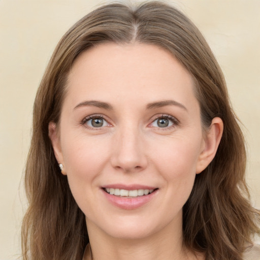 Joyful white young-adult female with long  brown hair and grey eyes