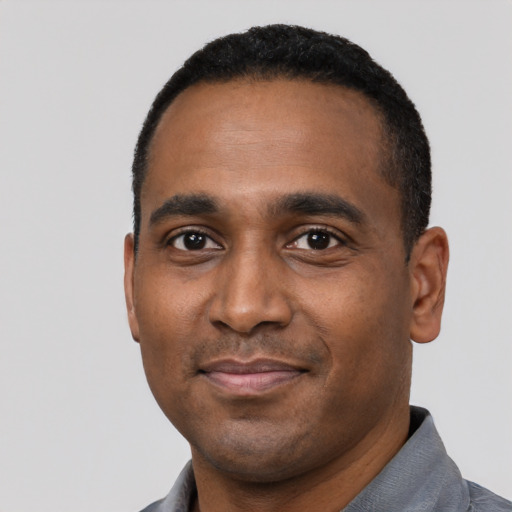 Joyful black young-adult male with short  black hair and brown eyes