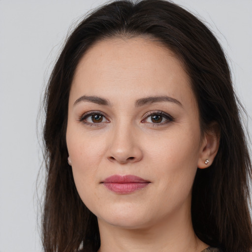 Joyful white young-adult female with long  brown hair and brown eyes