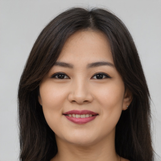 Joyful asian young-adult female with long  brown hair and brown eyes