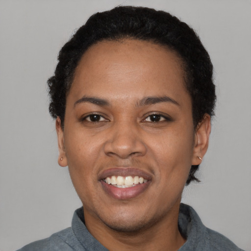 Joyful black adult female with short  black hair and brown eyes