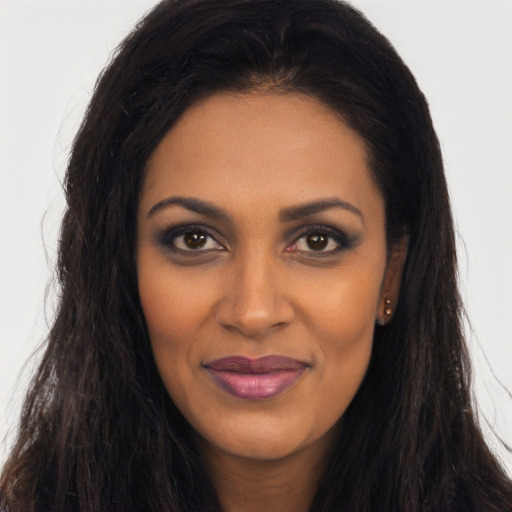 Joyful black young-adult female with long  brown hair and brown eyes