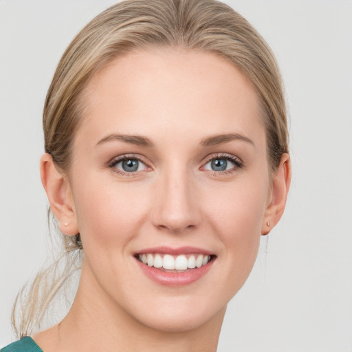 Joyful white young-adult female with medium  brown hair and blue eyes