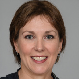 Joyful white adult female with medium  brown hair and grey eyes